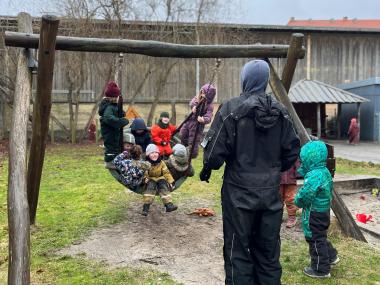 Børn, der gynger på legepladsen